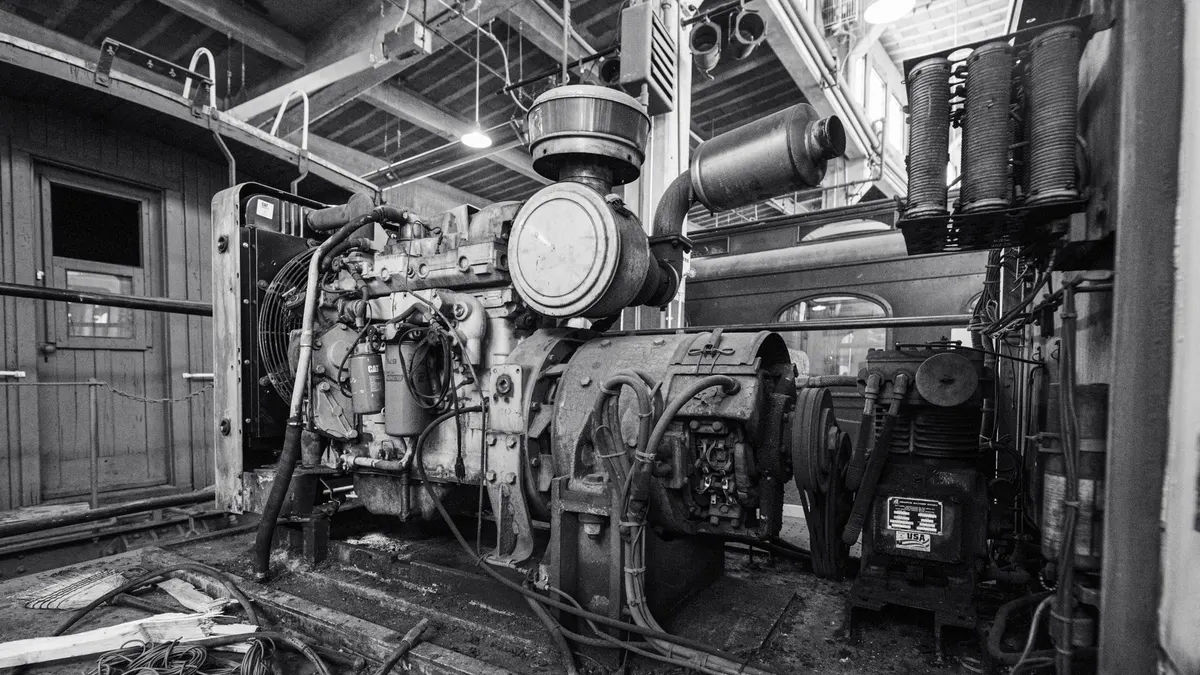 Industrial engine and pipework in a plant room, black and white