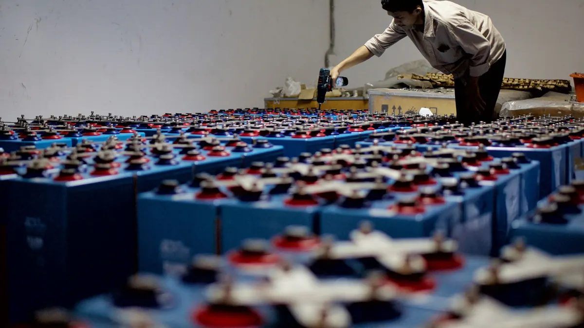 Engineer inspecting a large bank of batteries